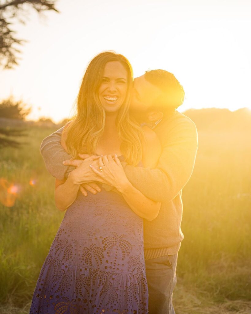 a couple hugging and kissing during a beautiful sunset