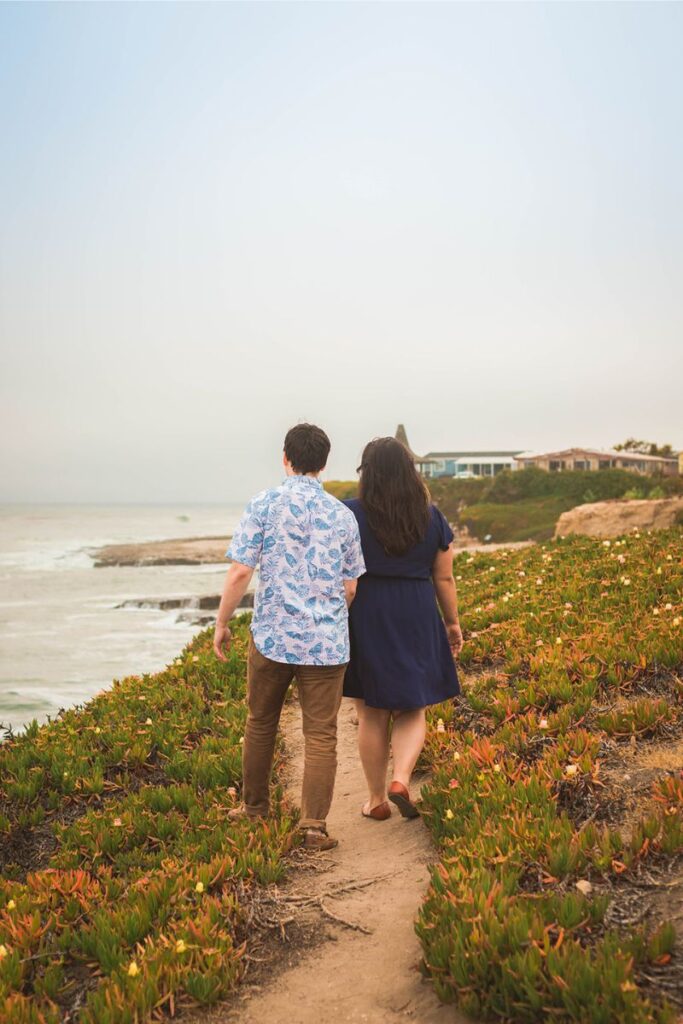 a couple walking down the beach dirt path