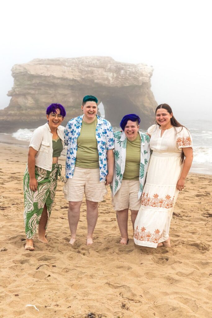 wedding party posing in front of a natural bridge 