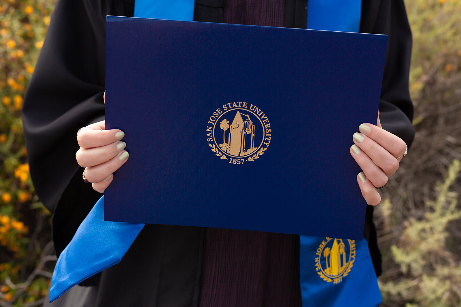 a navy blue diploma and light blue graduation stole