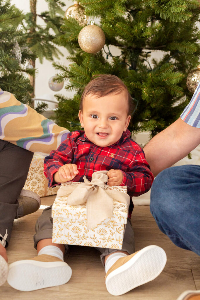 A young child smiles while holding a present.