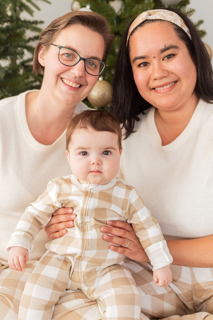 Two parents hold their child, smiling.