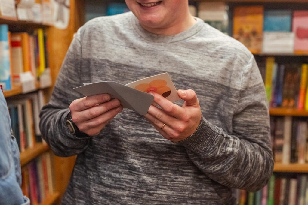 A person reading a small note in a bookstore 