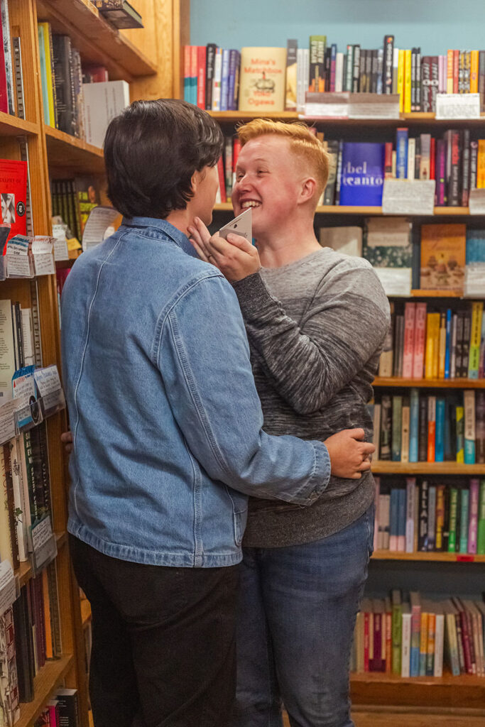 A person with a big smile on their face as they reach in to hug their partner 