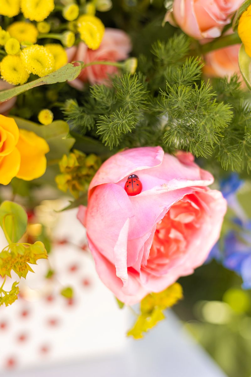 a floral bouquet featuring a plastic red lady bug