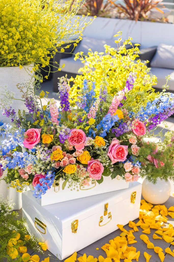 an opulent and colorful floral arrangement on top of two white boxes