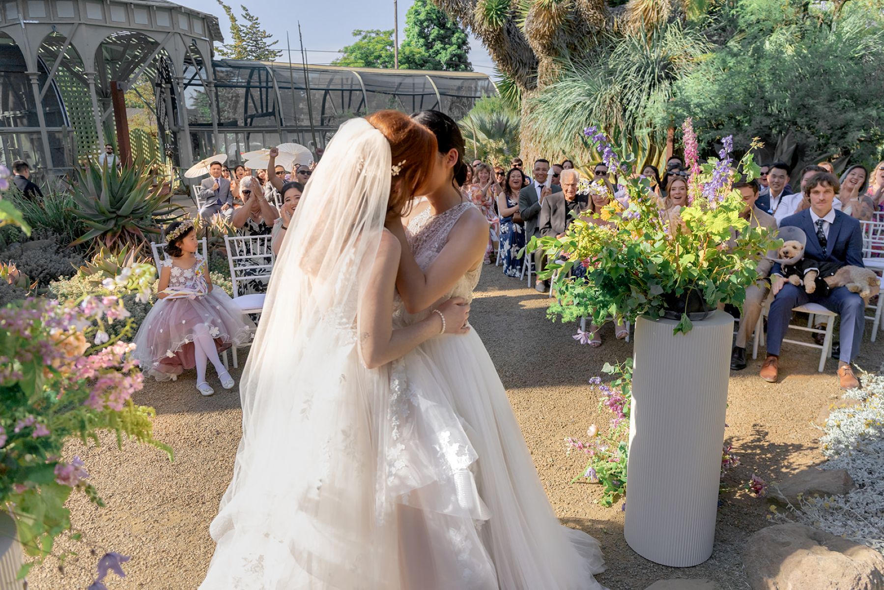 two women at their wedding ceremony at ruth bancroft garden kisisng each other during their wedding ceremony