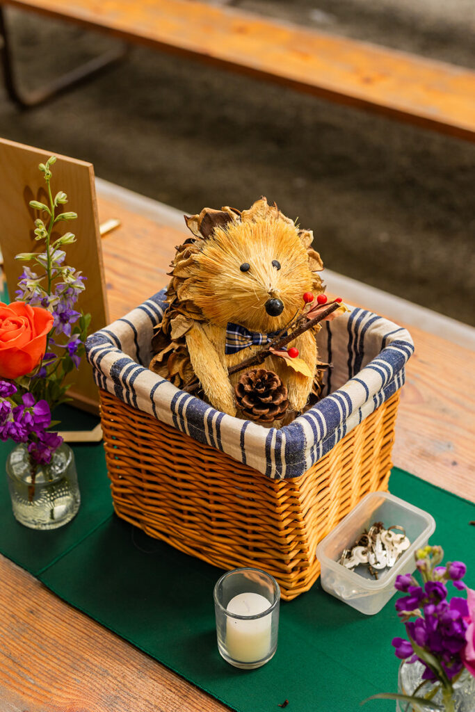 A small wooden carved animal in a basket on a table