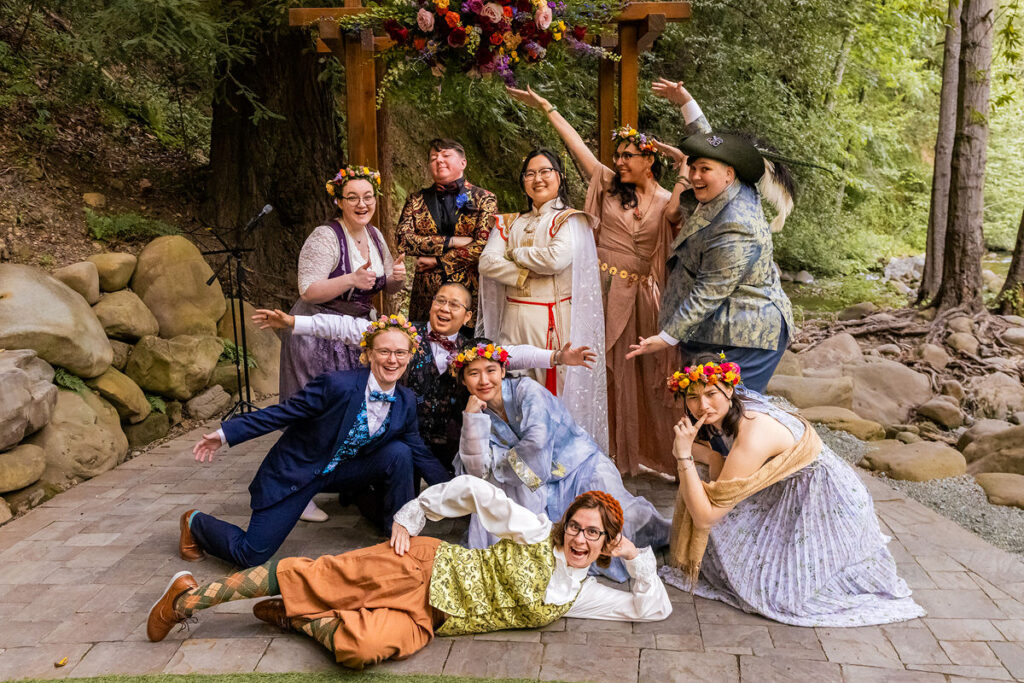 Newlyweds and their wedding party smiling and posing together