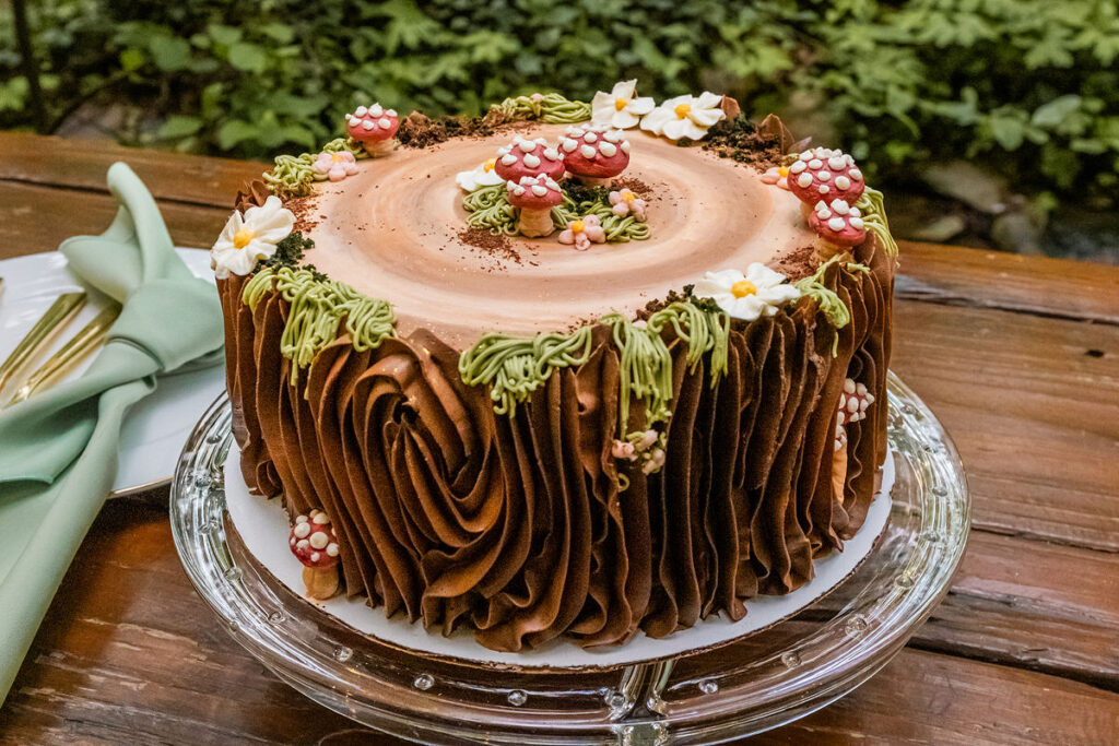A forest themed wedding cake with small mushrooms on top