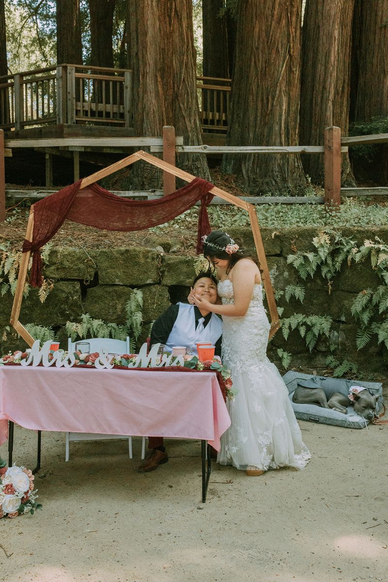 a couple embracing each other at their reception outdoors in the picnic area of peterson grove
