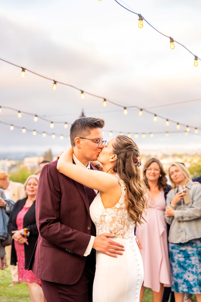 a couple kissing under string lights at their wedding reception at the camron stanford house 