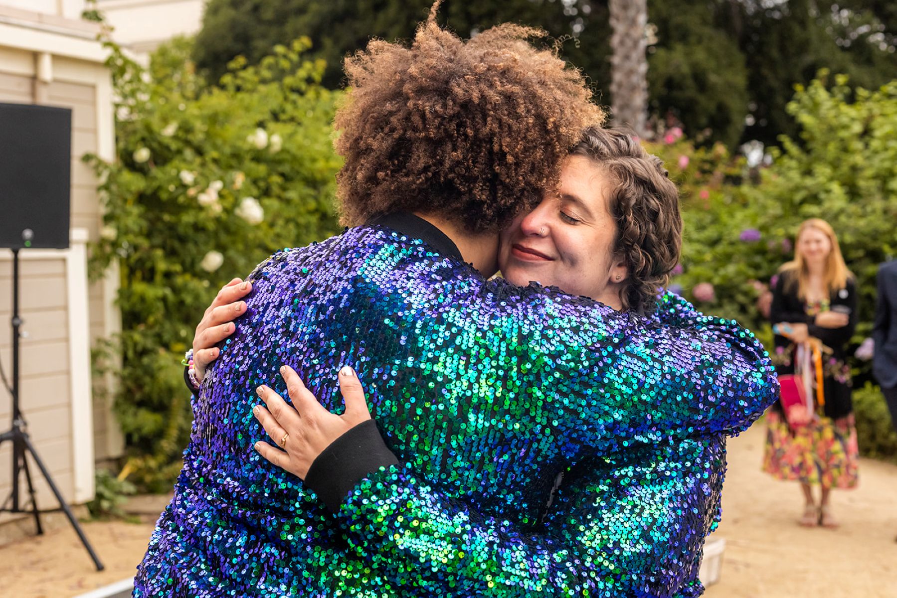 a couple wearing matching sparkling jackets hugging each other 
