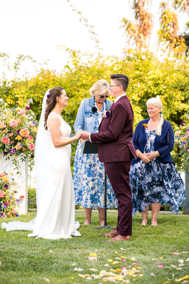 a couple having their wedding ceremony and holding hands at camron stanford house 