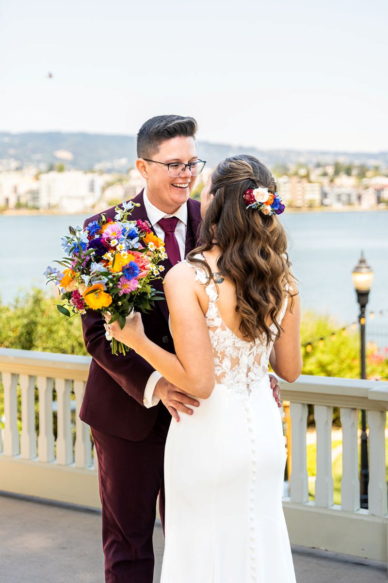 a couple standing on the deck at camron stanford house sharing a first look on the day of their wedding 
