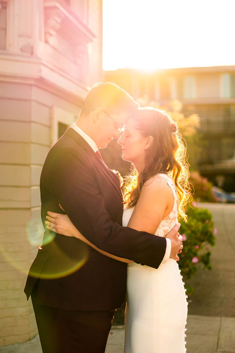 a couple with their heads pressed together embracing at golden hour 