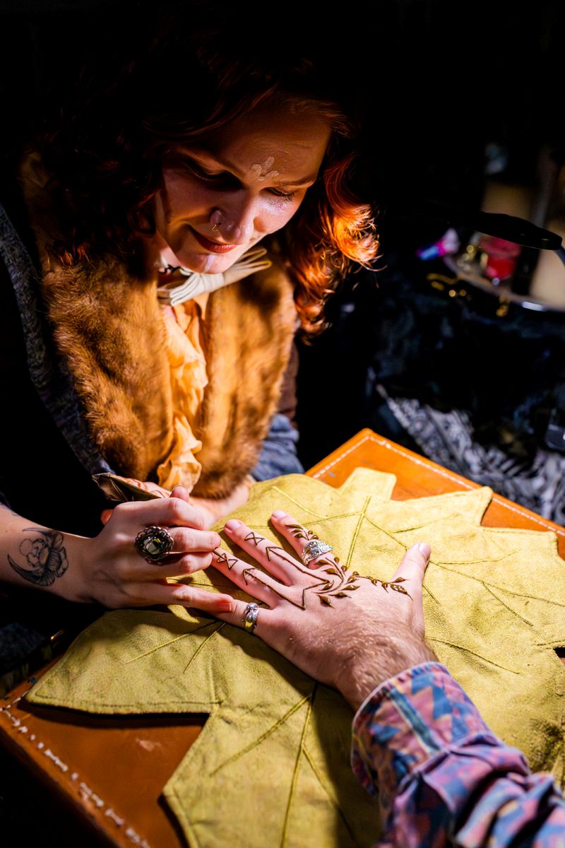 a woman doing henna at a wedding reception 