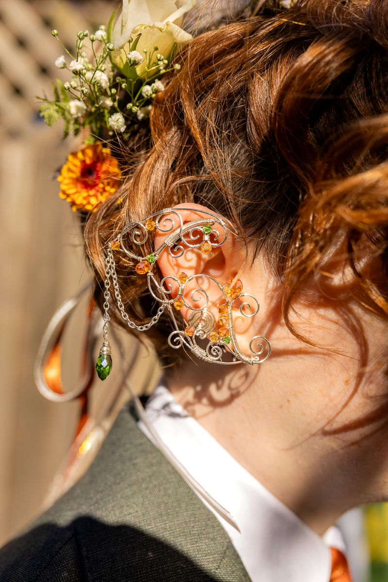 a person wearing a floral crown and a large earring 