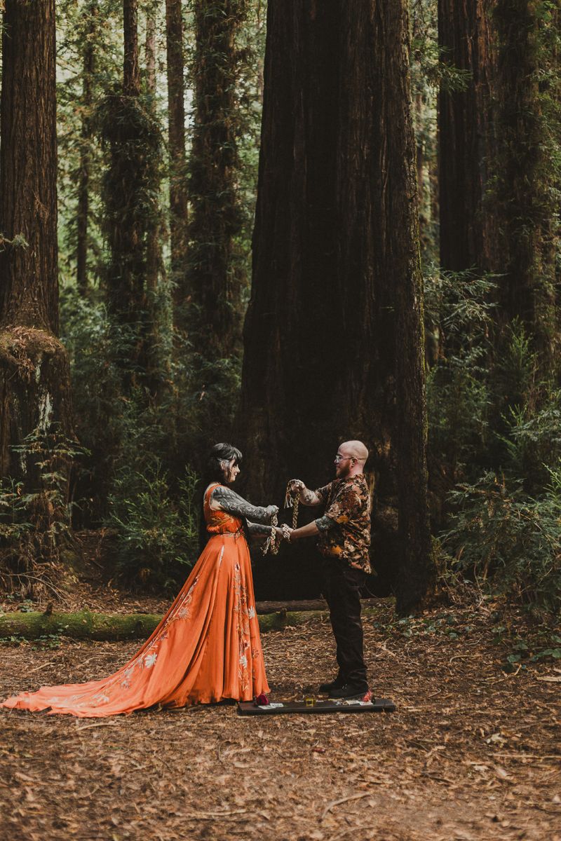 a couple having a wiccan wedding ceremony in henry cowell state park 