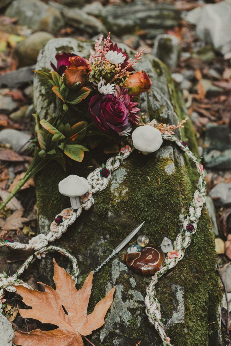 a rock covered in moss and flowers and jewelery 