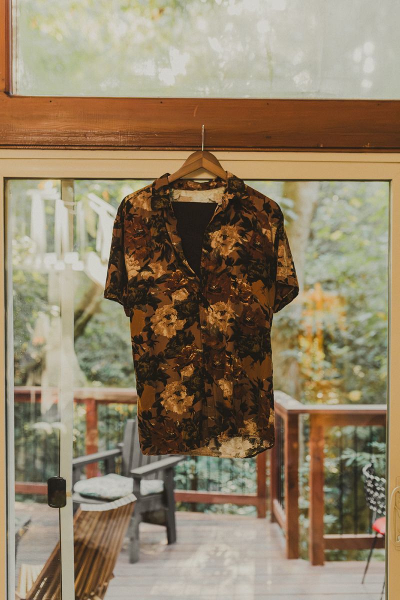 a floral patterned shirt hanging on a hook next to a window