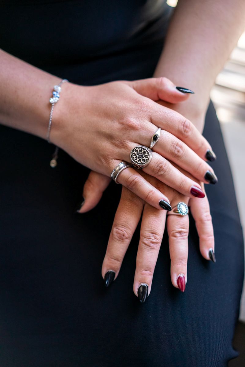 a person showing off their nails that are painted red and different rings 