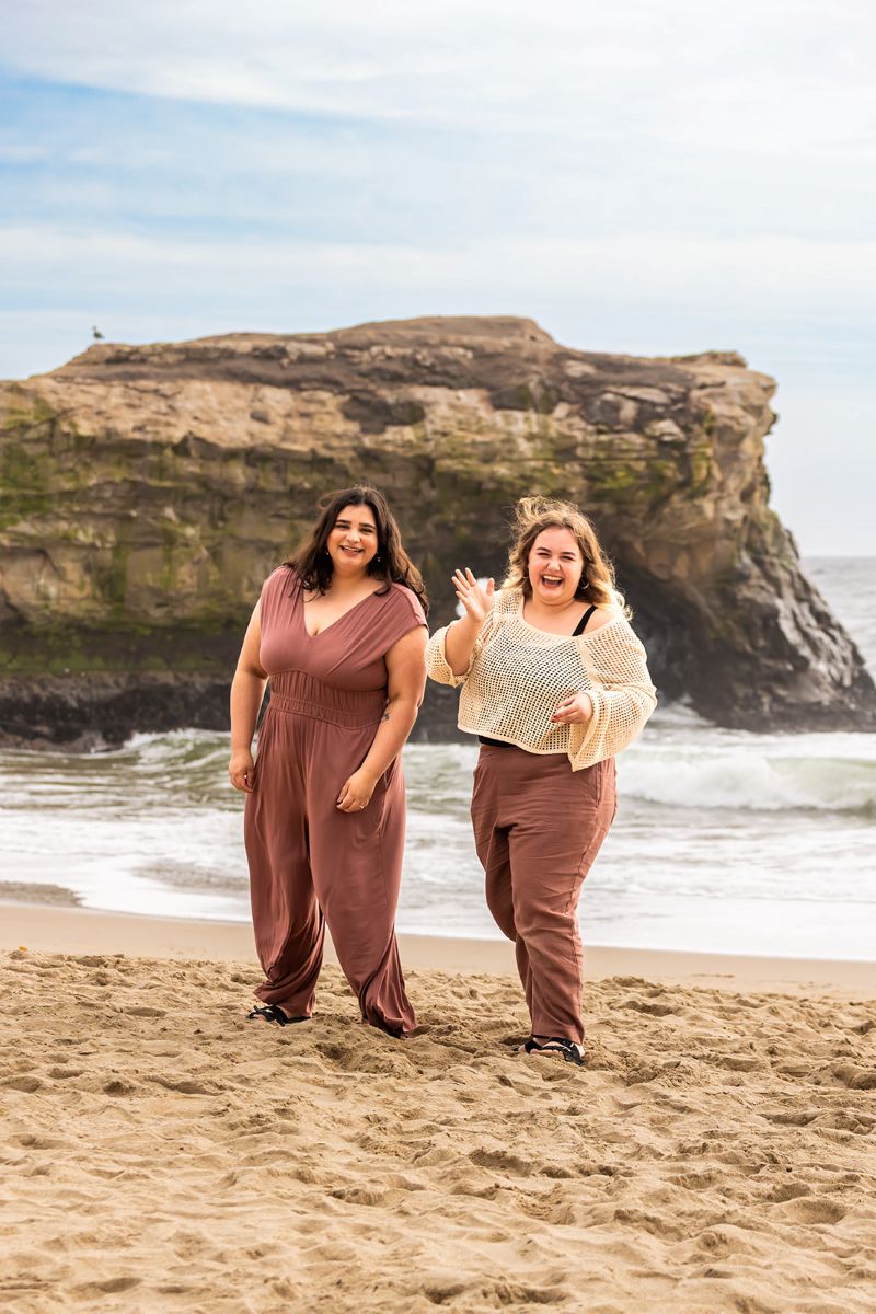 a couple laughing in the sand at natural bridge in santa cruz 