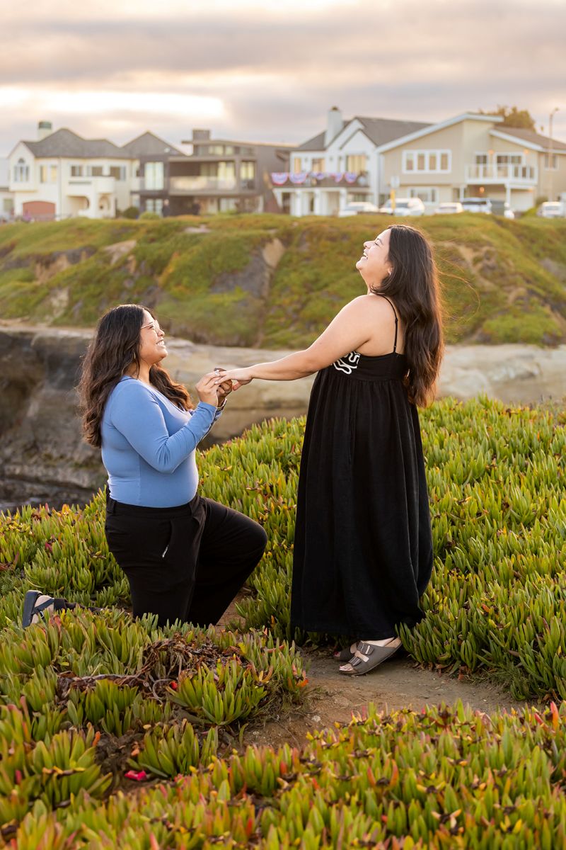 a woman proposing on west cliff drive at sunset 
