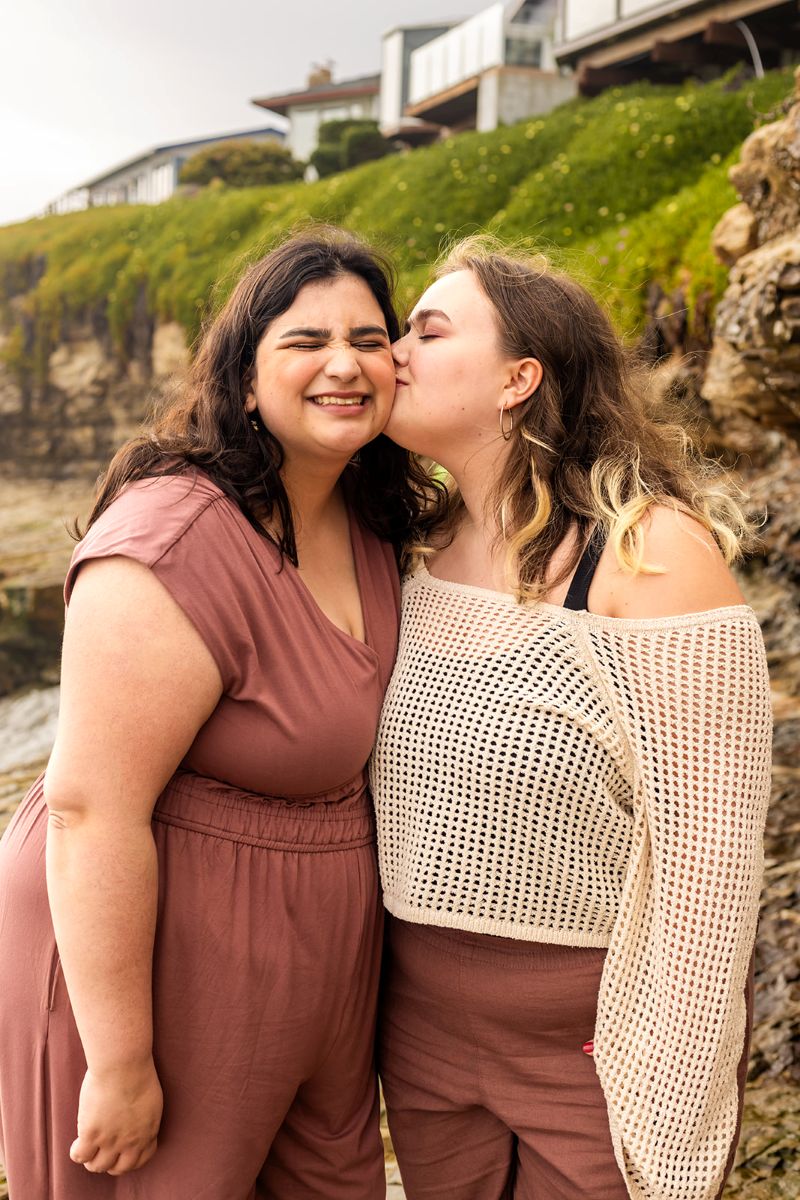 a woman kissing her partner on the cheek at natural bridges in santa cruz 
