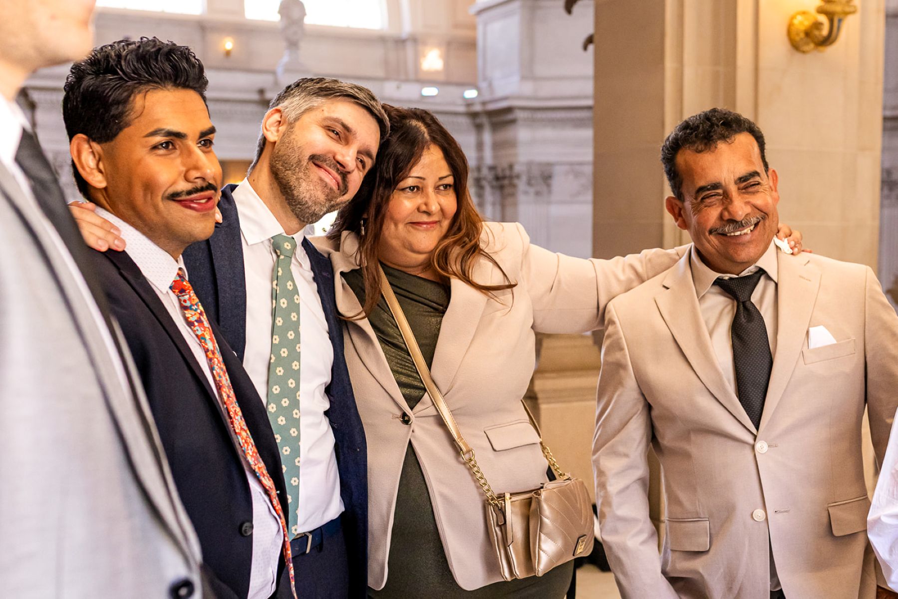 a family standing together watching a wedding ceremony in san francisco city hall