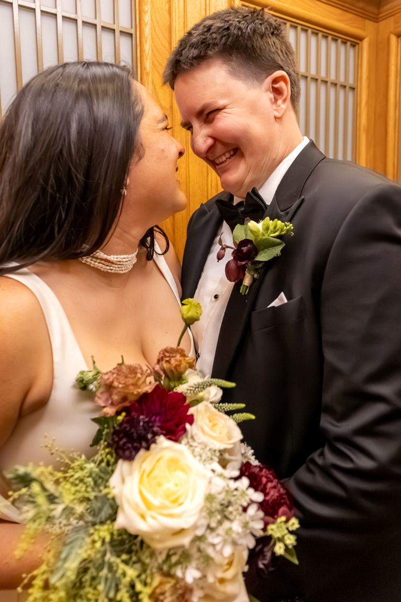 a couple smiling at each other inside an elevator in san francisco city hall