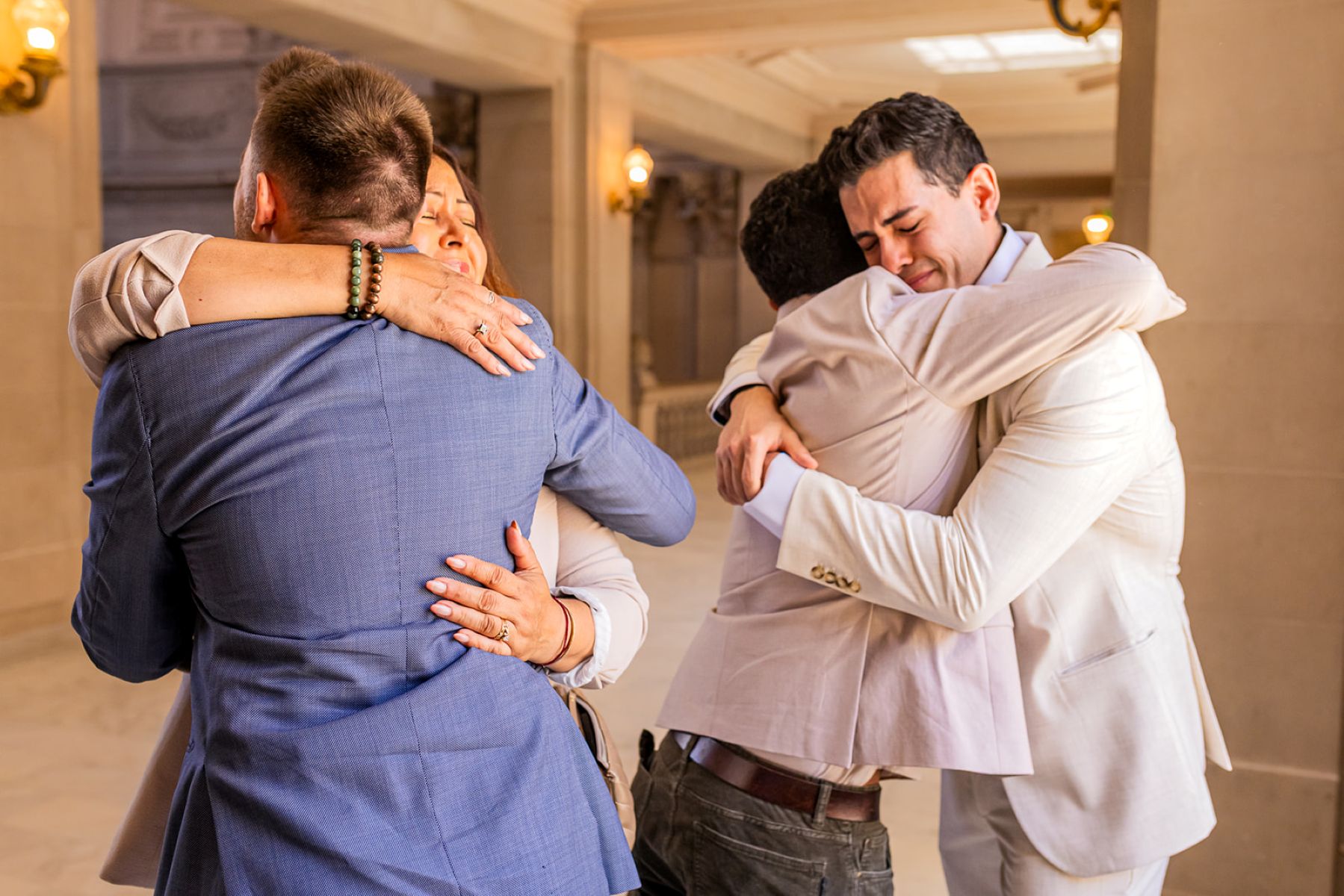 a couple embracing their parents after their wedding ceremony in san francisco city hall