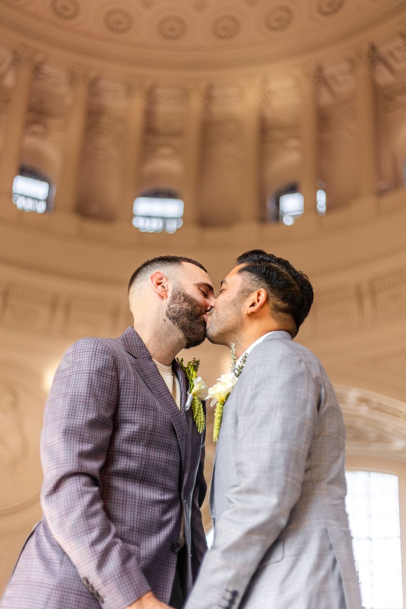 a couple kisssing underneath the dome in san francisco city hall