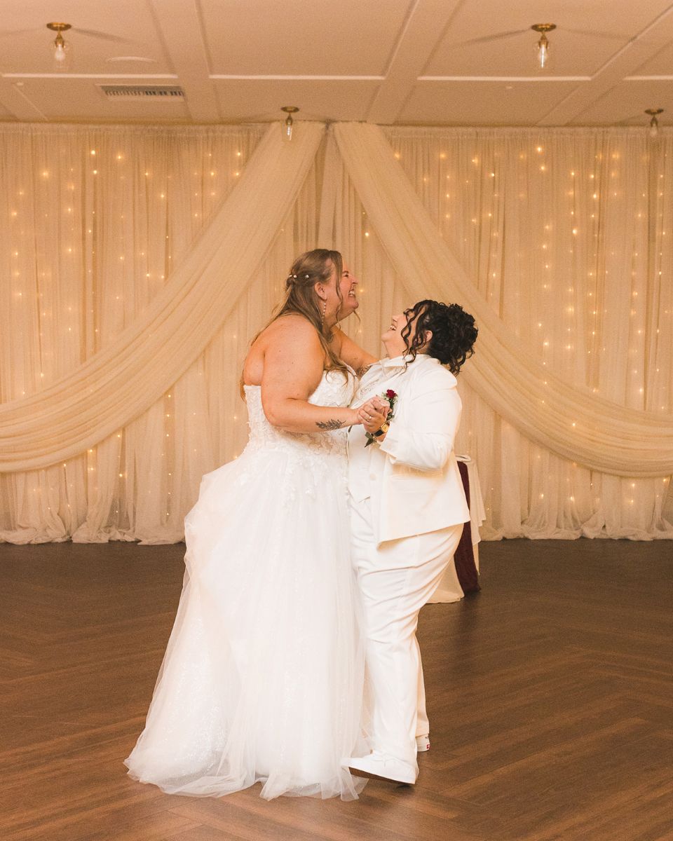 two brides dancing at their wedding reception at san ramon waters and laughing with one another