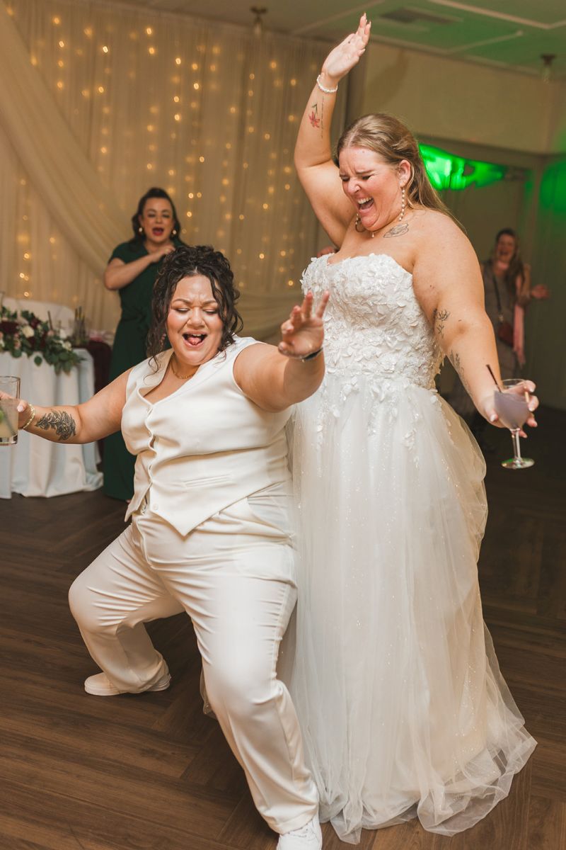 two brides dancing with each other at their wedding reception