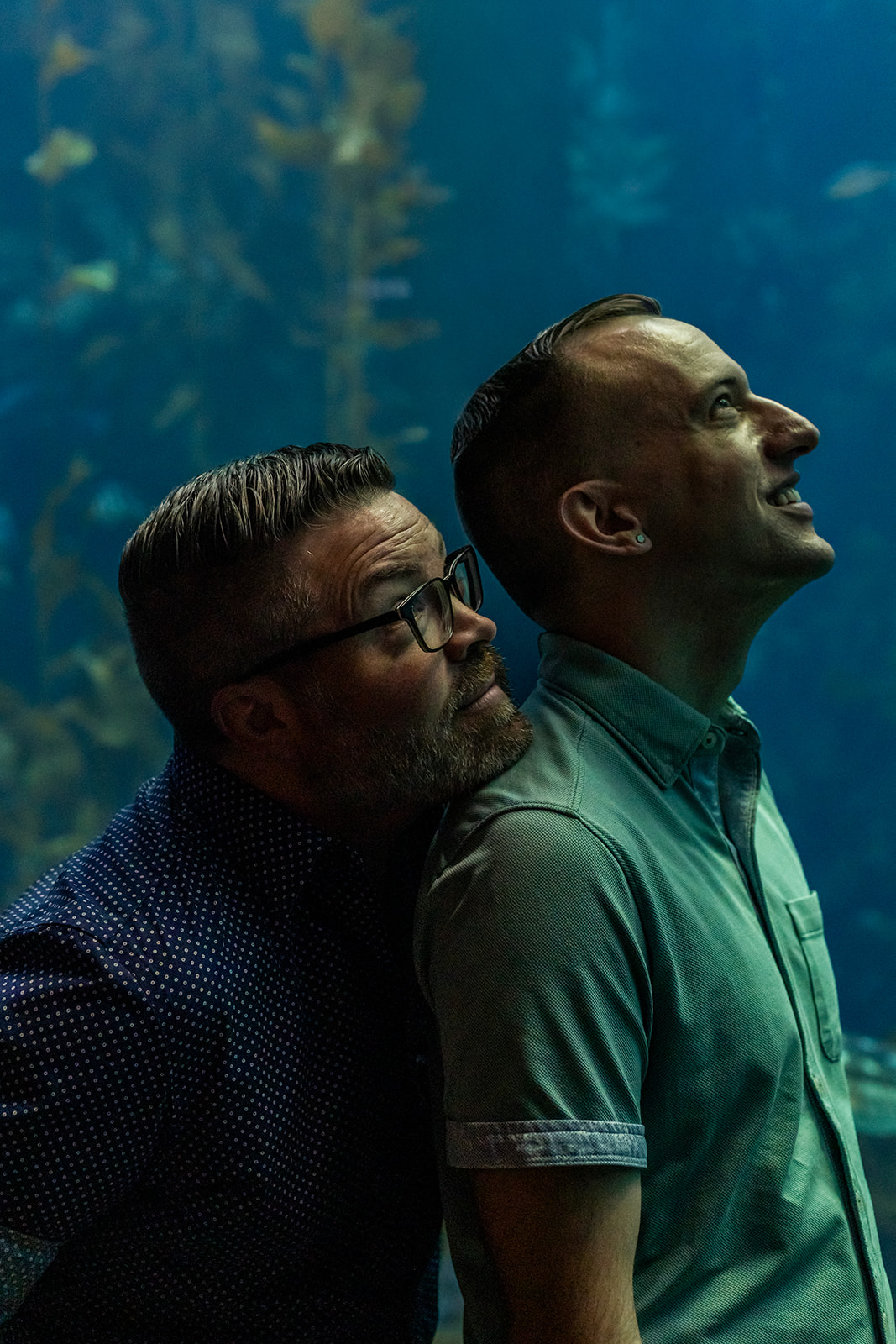 a couple inside of the Monterey Bay Aquarium taking engagement photos 