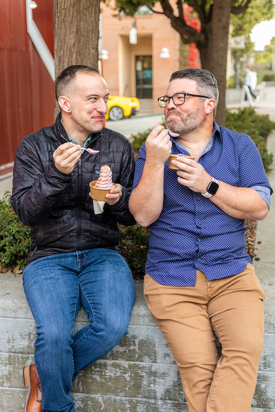 a queer couple enjoying ice cream together in cannery row during their engagement session 